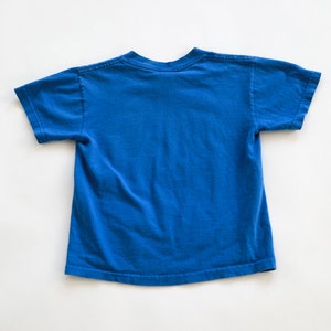 Puede incluir: Una camiseta azul lisa de manga corta. La camiseta est&aacute; hecha de algod&oacute;n suave y c&oacute;modo.