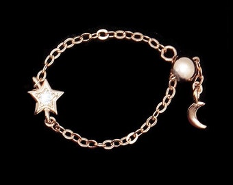 Adjustable sterling silver chain ring with rose gold plating and cubic zirconia with a star and small moon pendant