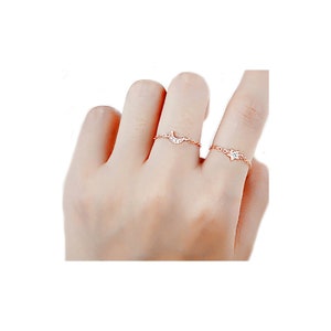May include: Two delicate gold rings with a crescent moon and a star design. The rings are adorned with small sparkling stones.