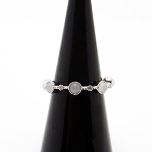 May include: A silver ring with five white stones set in a delicate band.