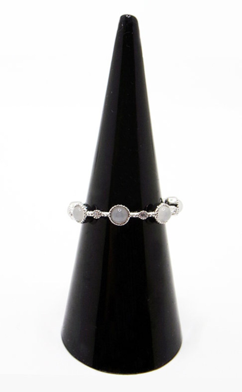 May include: A silver ring with five white stones set in a delicate band.
