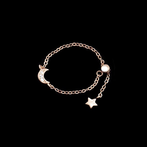 Anillo de cadena ajustable de plata esterlina con baño de oro rosa y circonitas con luna y pequeña estrella colgando
