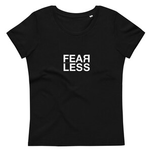 Könnte beinhalten: Schwarzes T-Shirt mit weißem Text, der "FEAR LESS" lautet.