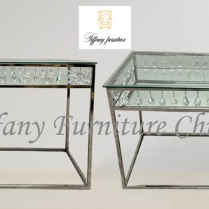 May include: Two silver metal end tables with glass tops and crystal accents. The tables are square and rectangular in shape. The text "Tiffany Furniture Chicago" is visible in the image.