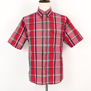 May include: A short-sleeved, button-down shirt in a red plaid pattern. The shirt features a button-down collar, a chest pocket, and a classic fit. The plaid design includes red, green, white, and navy blue stripes.