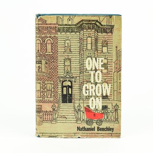 May include: Vintage book cover with a detailed illustration of a brownstone building. The title "ONE TO GROW ON" is in large white letters. A red baby carriage is in the foreground. The author's name, Nathaniel Benchley, is at the bottom.