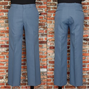 Könnte beinhalten: Eine blaue, weit geschnittene Hose mit geradem Schnitt. Die Hose hat einen Reißverschluss und Gürtelschlaufen.