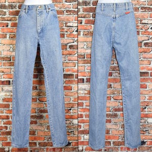 Peut inclure: Un jean en denim bleu clair &agrave; jambe droite. Le jean a une braguette &agrave; boutons et cinq poches.