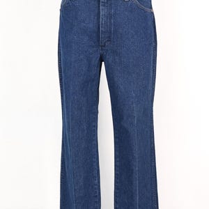 May include: Dark blue denim jeans with a classic five-pocket design. The jeans have a straight leg cut and a button and zipper closure. The fabric appears to be a medium weight denim. The jeans are displayed on a mannequin.