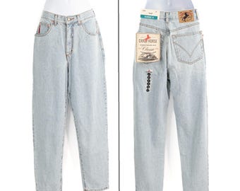 May include: Light wash denim jeans with a classic fit, displayed on a mannequin. The jeans have a high waist, a button and zip closure, and pockets. A tag with the brand name "Crazy Horse" is attached to the back.