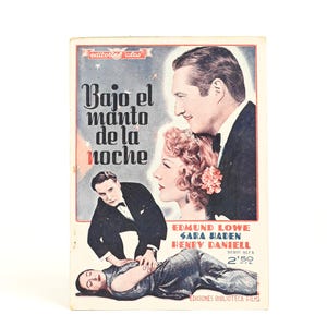 May include: Vintage movie poster titled "Bajo el manto de la noche" featuring illustrations of actors and actresses. The poster has a light blue background with text and images in black, red, and white. The poster is from "Ediciones Biblioteca Films".