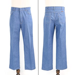 K&ouml;nnte beinhalten: Hellblaue Jeans mit klassischem F&uuml;nf-Taschen-Design. Die Jeans haben einen geraden Beinverlauf und einen Knopf- und Rei&szlig;verschluss. Die Vorder- und R&uuml;ckseite der Jeans werden gezeigt, wobei die Details der Taschen und N&auml;hte hervorgehoben werden.