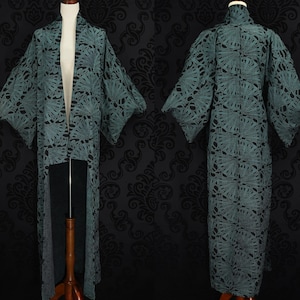 May include: A long, teal blue kimono with a floral pattern. The kimono is open in the front and has long sleeves.