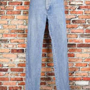 Peut inclure: Un jean en denim bleu clair &agrave; jambe droite. Le jean a une braguette &agrave; boutons et cinq poches.
