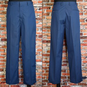 May include: A pair of navy blue dress pants. The pants have a classic, straight-leg design with a button and zipper closure. The front view shows the pleats and pockets, while the back view reveals the back pockets and belt loops. The pants are made of a smooth, solid fabric.