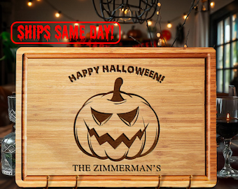 May include: A brown wooden cutting board with a carved pumpkin and the text "Happy Halloween!" and "The Zimmerman's".