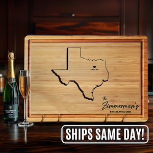May include: A wooden cutting board with a laser-engraved outline of the state of Texas. The board has a heart-shaped cutout over Dallas, Texas, and the text "The Zimmerman's Established 2021".