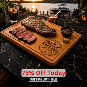 May include: A wooden chopping board with a grilled steak and sliced steak. The board has a carved border and the text "Nick's Grill" in a circular design. A glass of cola, a small bowl of peppercorns, and a copper bowl of salt are also present.