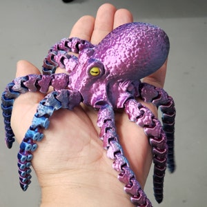 May include: A purple and blue octopus figurine with segmented tentacles. The octopus has a textured, iridescent finish.