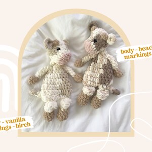 Pode incluir: Dois peluches de vaca de croch&ecirc;, um com corpo de baunilha e marcas de b&eacute;tula, e o outro com corpo de pedra de praia e marcas de torradas.