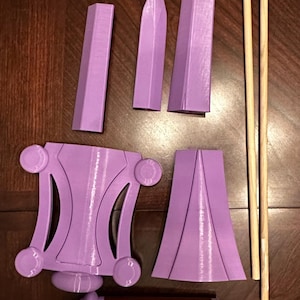 May include: A set of purple 3D printed pieces for a model of a sword, along with two wooden dowels.