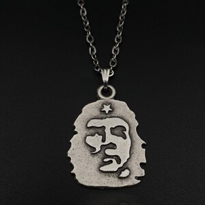 K&ouml;nnte beinhalten: Eine silberne Kettenkette mit einem Anh&auml;nger, der ein Profil von Che Guevara mit einem Stern &uuml;ber seinem Kopf zeigt.