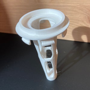 May include: White plastic 3D printed object with a round top and a hollow, lattice-like base.