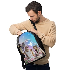 Puede incluir: Mochila negra con un diseño surrealista. Presenta estatuas clásicas, mariposas y flores dentro de una forma de burbuja. La mochila tiene correas ajustables y un asa superior. El diseño incorpora tonos de azul, morado y rosa.
