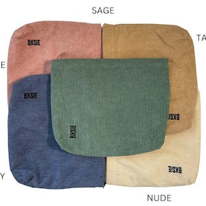 Pode incluir: Uma cole&ccedil;&atilde;o de pe&ccedil;as de tecido de veludo cotel&ecirc; nas cores rosa, s&aacute;lvia, bege, nude e azul marinho. Cada pe&ccedil;a tem formato retangular com cantos arredondados e a palavra "BXBSIE" impressa. Os tecidos est&atilde;o dispostos sobre um fundo branco.