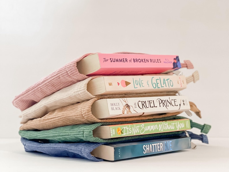 Pode incluir: Uma pilha de cinco livros, cada um em uma capa de livro de veludo cotel&ecirc;. Os livros t&ecirc;m t&iacute;tulos como "The Summer of Broken Rules" e "Love & Gelato". As capas s&atilde;o em tons de rosa, bege, castanho claro, verde e azul.