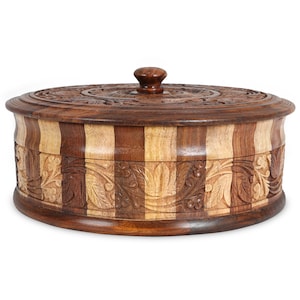 May include: A round wooden box with a carved floral design and a striped pattern. The box has a lid with a knob on top.