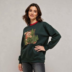 May include: Dark green sweatshirt with a red collar. The sweatshirt features a graphic of a bear wearing a Santa hat, surrounded by Christmas trees. The bear graphic is in shades of brown, green, and red.