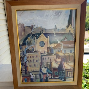 May include: A framed painting depicting a cityscape with a church in the center. The painting is done in a loose, impressionistic style with a focus on color and texture. The colors are muted and earthy, with shades of brown, gray, and blue dominating the composition. The painting is signed in the lower right corner with the artist's initials.
