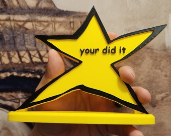 May include: A yellow star-shaped award with a black outline and the text "your did it" printed on it.