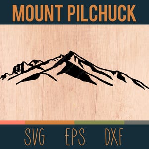 May include: Black and white silhouette of Mount Pilchuck, a mountain range with multiple peaks. The image is on a woodgrain background with the text "MOUNT PILCHUCK" at the top.