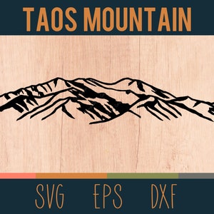 May include: Black and white line art illustration of the Taos Mountains. The image is on a woodgrain background with the text "TAOS MOUNTAIN" at the top and "SVG EPS DXF" at the bottom.
