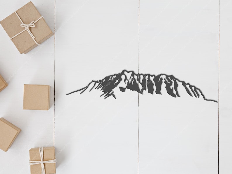 Op de afbeelding: Een zwart silhouet van een bergketen op een witte houten achtergrond. Er zijn verschillende kleine bruine cadeaudoosjes op het oppervlak.