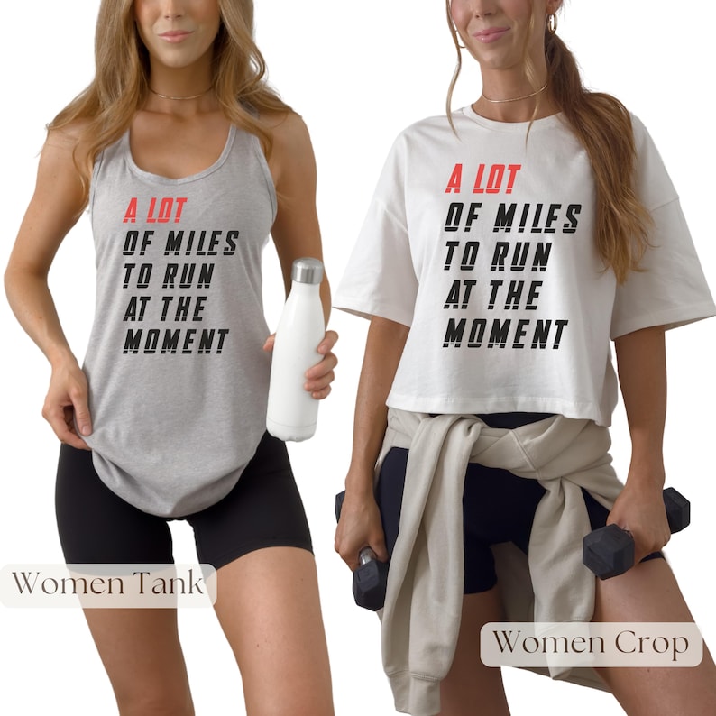 May include: A light gray tank top and a white crop top, both with the text "A LOT OF MILES TO RUN AT THE MOMENT" in black and red. The tank top is paired with black shorts, and the crop top is paired with black shorts and a gray sweatshirt.