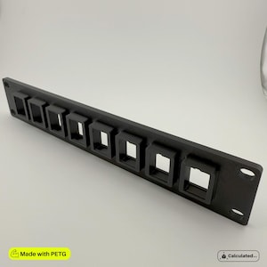 K&ouml;nnte beinhalten: Schwarze Kunststoff-Wandplatte mit acht rechteckigen &Ouml;ffnungen. Die Platte ist f&uuml;r die Aufnahme von Kabeln oder Dr&auml;hten konzipiert.