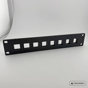 K&ouml;nnte beinhalten: Schwarzer Metall-Rack mit acht quadratischen Aussparungen f&uuml;r die Kabelverwaltung.
