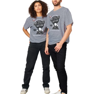 May include: Two people wearing gray t-shirts with the text "Mos Eisley Cantina" and a graphic of skulls. The shirts are paired with black jeans and white sneakers. The image is set against a white background.