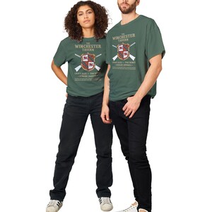 May include: Two people wearing green t-shirts with a vintage-style graphic of "The Winchester Tavern" featuring a coat of arms, crossed rifles, and the text "Craft Ales - Fine Wines - Hungry Zombies".