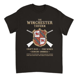 May include: Black t-shirt with a vintage-style graphic of a coat of arms with crossed rifles and the text "The Winchester Tavern", "Craft Ales", "Fine Wines", "Hungry Zombies", "Authentic Pub Atmosphere", "Impenetrable(ish) Fortress", "Come on in and wait for things to blow over".