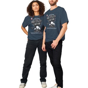 May include: Two people wearing navy blue t-shirts with the text "Mos Eisley Cantina" and a graphic of three alien heads. The shirts are paired with black jeans and white sneakers. The text also includes "Featuring Lux" and other text.