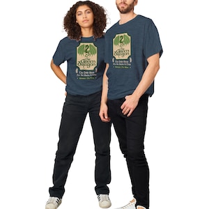 May include: Two people wearing blue heather t-shirts with a green dragon graphic and the text "The Green Dragon" and "The Only Brew for the Brave & True".