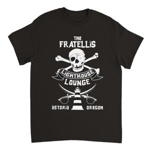 May include: Black t-shirt with a white graphic design featuring a skull and crossbones, a lighthouse, and the text "The Fratellis Lighthouse Lounge Astoria Oregon".