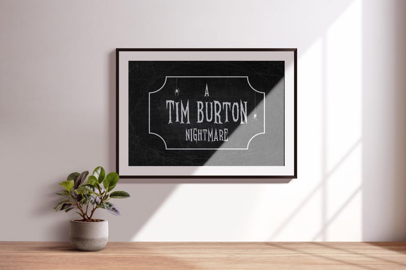 K&ouml;nnte beinhalten: Gerahmter Kunstdruck mit dem Text "A Tim Burton Nightmare" in wei&szlig;er, Vintage-Schrift auf schwarzem Hintergrund. Der Druck befindet sich in einem schwarzen Rahmen und h&auml;ngt an einer wei&szlig;en Wand. Eine kleine Topfpflanze steht auf einer Holzoberfl&auml;che.