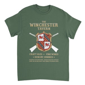 May include: A green t-shirt with a vintage-style graphic of a coat of arms and the text "The Winchester Tavern." The graphic also includes crossed rifles and the text "Craft Ales, Fine Wines, Hungry Zombies." The text below the graphic reads "Authentic Pub Atmosphere - Impenetrable(ish) Fortress. Come on in and wait for things to blow over."