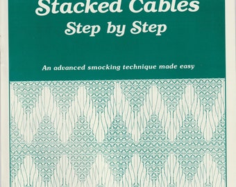 Könnte beinhalten: Ein Buch mit dem Titel "Stacked Cables Step by Step" mit einem grünen Einband und einer weißen Illustration eines Smocking-Musters. Das Buch ist von Saudy Hunter und ist eine fortgeschrittene Smocking-Technik, die leicht gemacht wird.