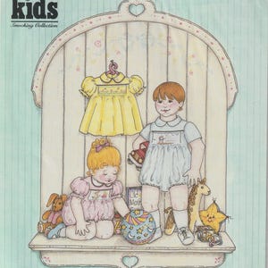 May include: A vintage illustration of a children's clothing pattern. The image features a yellow dress, a light blue romper, and two children with toys. The text includes "ab kids Smocking Collection" and "Ashley-Cory".